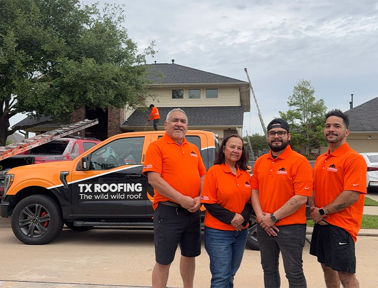 TX Roofing and Services team in orange company polos in front of a branded TX Roofing truck