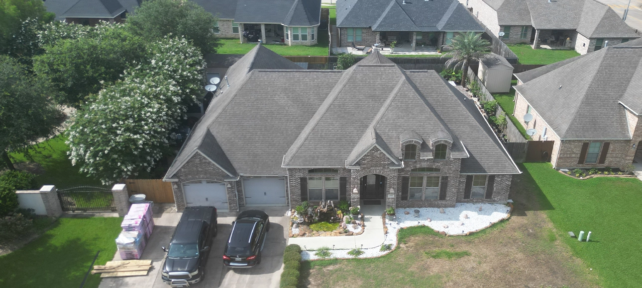 The same brick home before replacement, with faded and weathered shingles