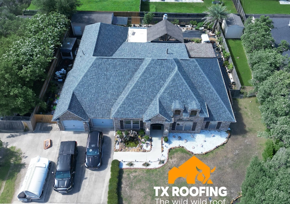 Aerial view of a brick home with a newly replaced gray shingle roof by TX Roofing